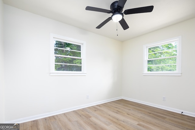 spare room with light wood-style floors, baseboards, and ceiling fan