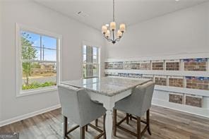 2700 Westgate Park Dr Unit 1A, Loganville, GA 30052 - dining area featuring a chandelier, dark wood-style floors, and baseboards