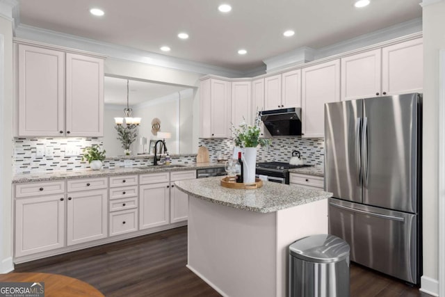 kitchen featuring stainless steel appliances, a sink, crown molding, dark wood-type flooring, and exhaust hood