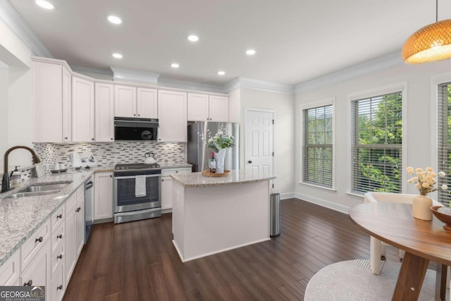 kitchen with stainless steel appliances, a sink, crown molding, backsplash, and dark wood finished floors