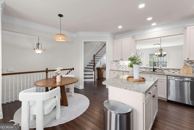 kitchen featuring stainless steel dishwasher, a sink, decorative backsplash, ornamental molding, and white cabinetry