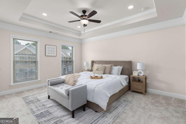 carpeted bedroom featuring a tray ceiling, ornamental molding, recessed lighting, baseboards, and a ceiling fan