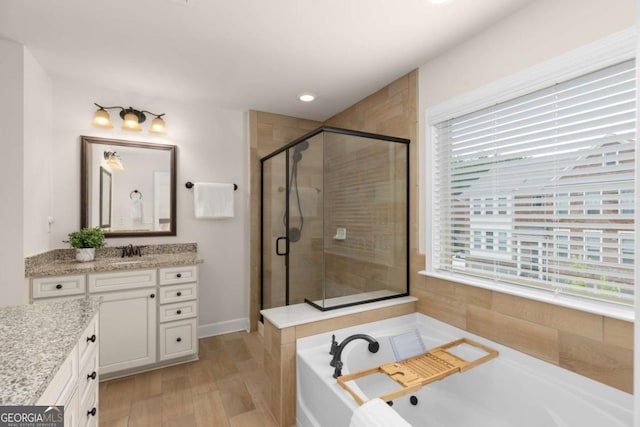 bathroom featuring a shower stall, a bath, vanity, wood finished floors, and recessed lighting