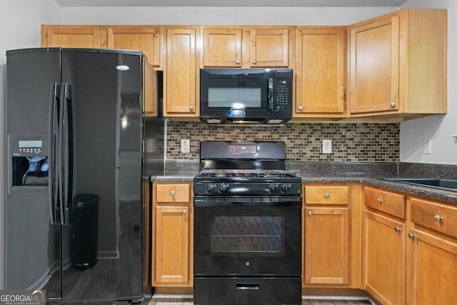kitchen with black appliances, tasteful backsplash, and a sink