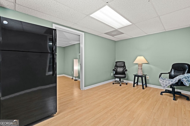 living area featuring a paneled ceiling, wood finished floors, and baseboards