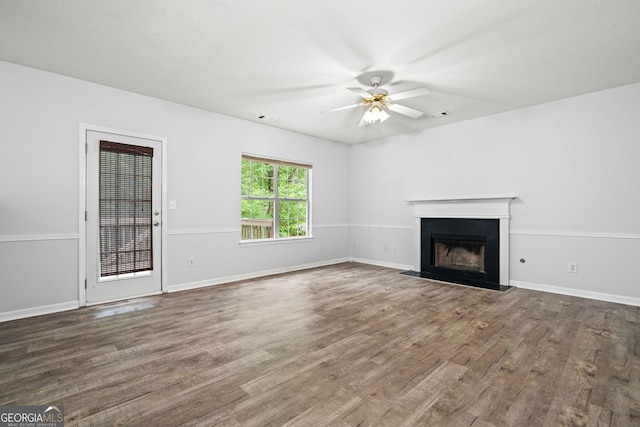 unfurnished living room with ceiling fan, a fireplace, wood finished floors, and baseboards