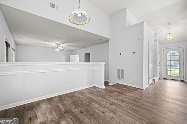 empty room with wood finished floors, a ceiling fan, and baseboards