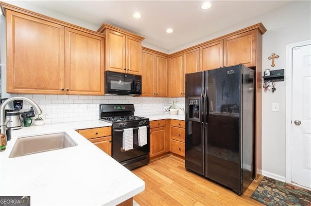 59 Creekside Blf, Hiram, GA 30141 - kitchen with black appliances, a sink, light countertops, light wood-type flooring, and tasteful backsplash