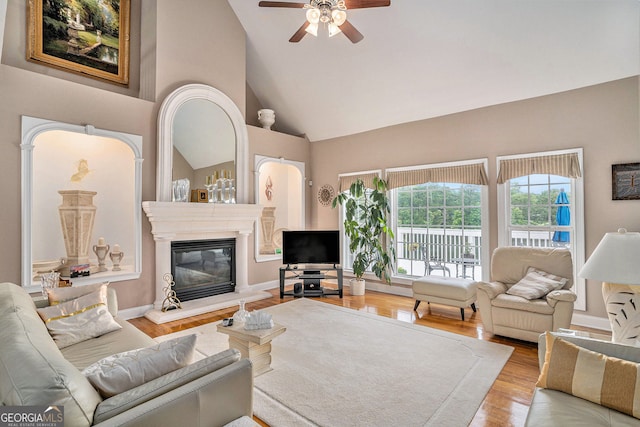 127 Courts Of Hampton, Hampton, GA 30228 - living area featuring a glass covered fireplace, wood finished floors, a ceiling fan, and high vaulted ceiling