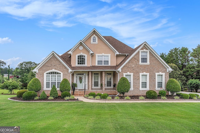 127 Courts Of Hampton, Hampton, GA 30228 - view of front of home with covered porch, a front lawn, brick siding, and stucco siding