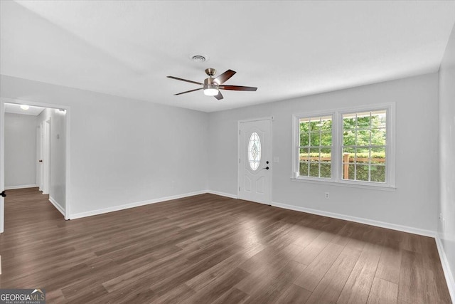 foyer entrance with ceiling fan, dark wood-type flooring, and baseboards