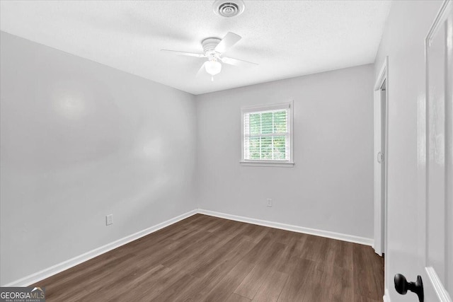 unfurnished bedroom featuring dark wood finished floors, baseboards, a textured ceiling, and a ceiling fan