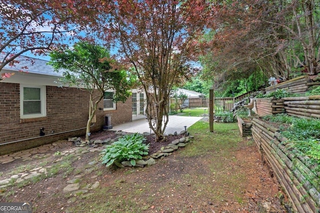 view of yard with a patio area, fence, and french doors