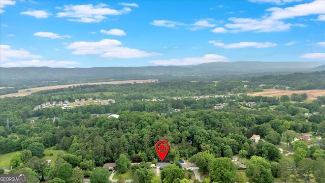 bird's eye view of a heavily wooded area and a mountainous background