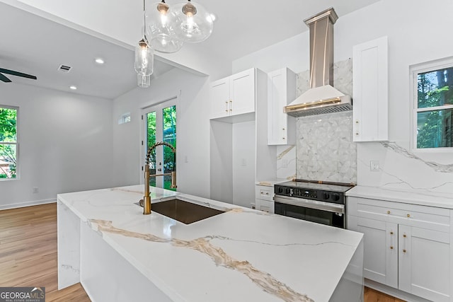 1835 Taylor Ave, East Point, GA 30344 - kitchen with stainless steel range with electric stovetop, a sink, wall chimney exhaust hood, tasteful backsplash, and white cabinetry