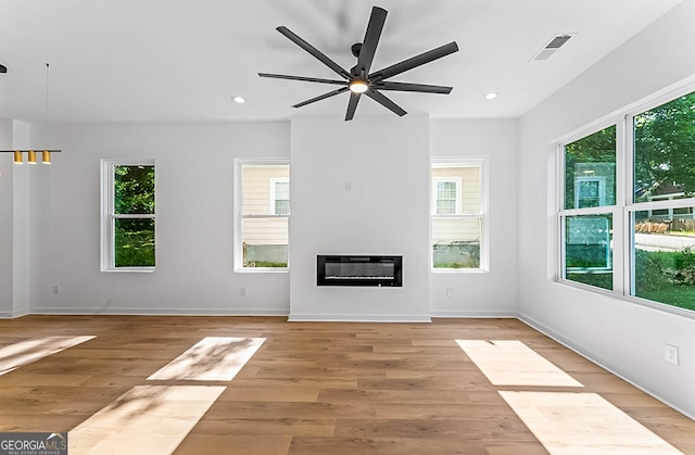 1835 Taylor Ave, East Point, GA 30344 - unfurnished living room featuring plenty of natural light, a ceiling fan, a glass covered fireplace, light wood-style floors, and recessed lighting
