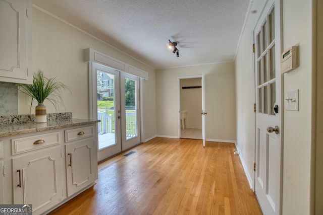 12 Riverview Rd SE, Rome, GA 30161 - unfurnished dining area featuring french doors, ornamental molding, light wood finished floors, a textured ceiling, and baseboards