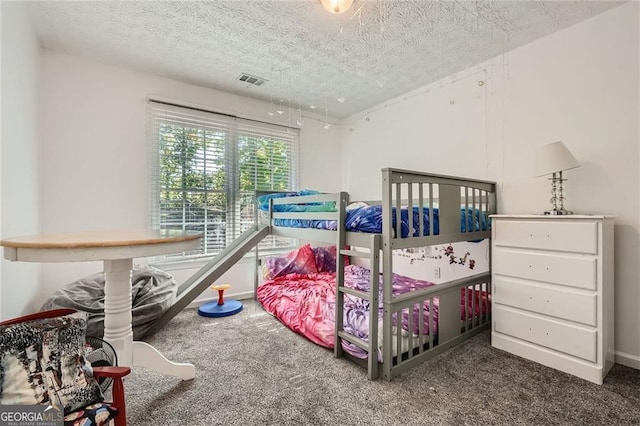 carpeted bedroom featuring a textured ceiling and baseboards
