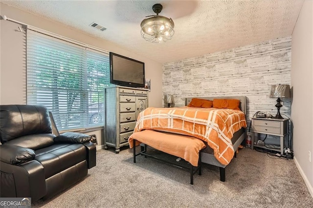 bedroom featuring a textured ceiling, light carpet, and baseboards