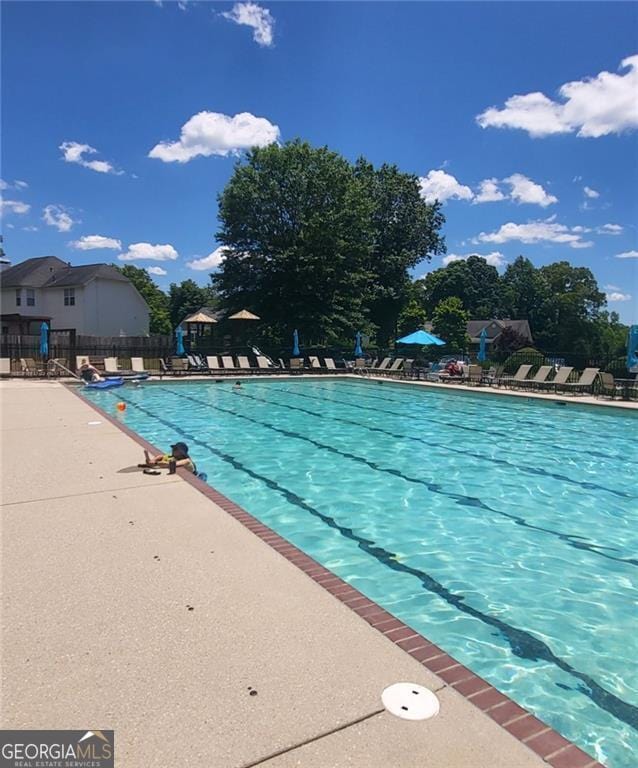 community pool with fence and a patio