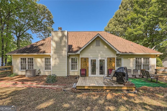 back of property with french doors, a deck, a chimney, central AC, and roof with shingles