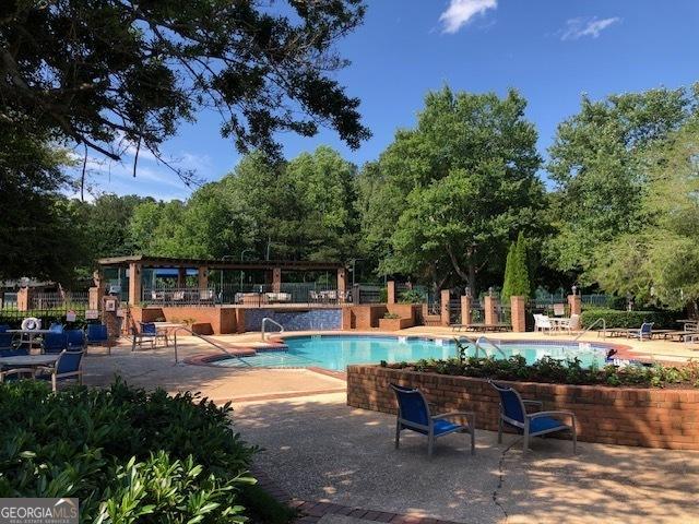 116 Royal Burgess Way, Mcdonough, GA 30253 - community pool featuring a patio area and view of wooded area