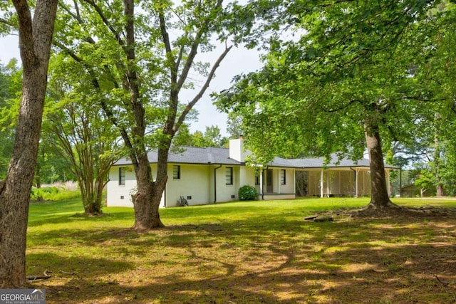 view of front of house with a chimney, a front lawn, and crawl space