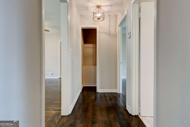 hall with dark wood-style floors and baseboards