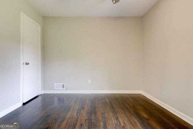 empty room featuring dark wood-style floors and baseboards