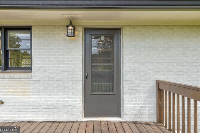 entrance to property featuring brick siding