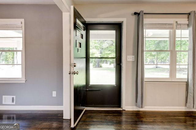 entryway with dark wood-style floors, baseboards, and healthy amount of natural light