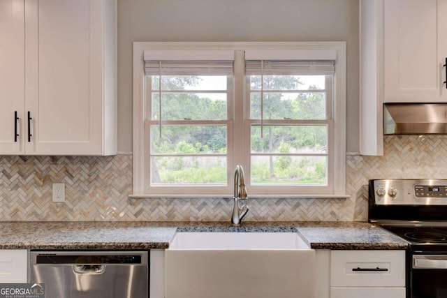 kitchen with stainless steel appliances, wall chimney range hood, a sink, decorative backsplash, and white cabinets