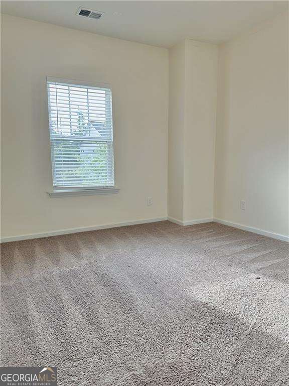 unfurnished room with baseboards and carpet floors