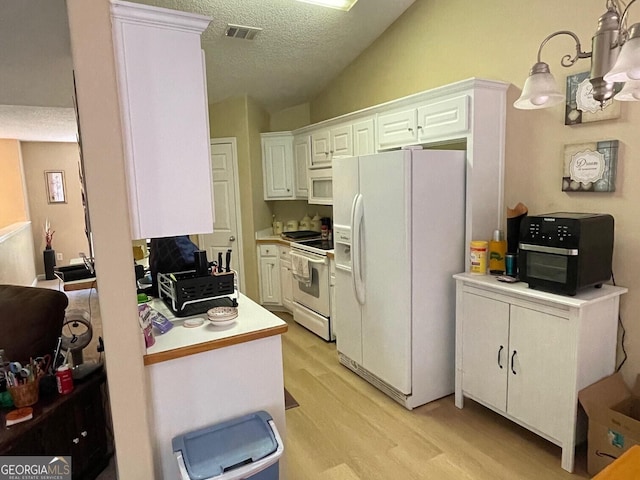 397 E Sycamore Dr, Winder, GA 30680 - kitchen featuring white appliances, light wood-type flooring, lofted ceiling, white cabinetry, and light countertops