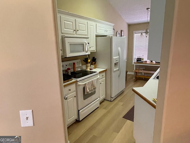 397 E Sycamore Dr, Winder, GA 30680 - kitchen featuring white appliances, white cabinets, light wood finished floors, light countertops, and a textured ceiling