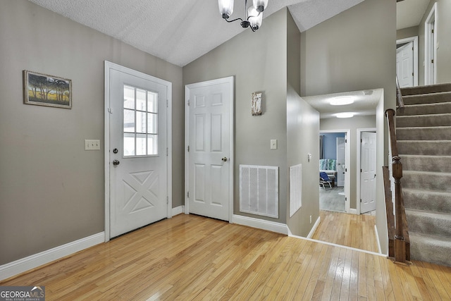 109 Cannon Rd, Sharpsburg, GA 30277 - entryway featuring wood-type flooring, stairway, vaulted ceiling, baseboards, and a chandelier