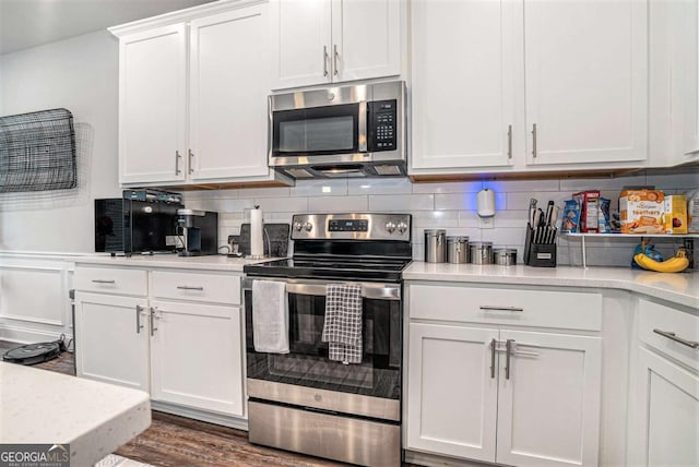 450 Rockfern Ct, Lilburn, GA 30047 - kitchen with appliances with stainless steel finishes, light countertops, white cabinets, and decorative backsplash
