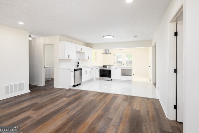 754 Wright Dr, Columbus, GA 31907 - kitchen featuring appliances with stainless steel finishes, wall chimney exhaust hood, wood finished floors, recessed lighting, and white cabinets