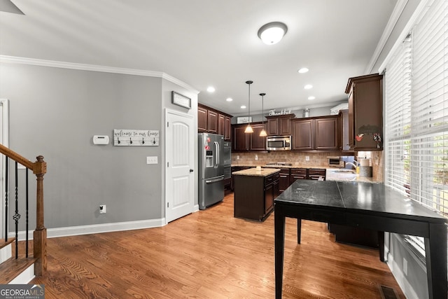 1050 Double Branches Ln, Dallas, GA 30132 - kitchen with appliances with stainless steel finishes, ornamental molding, a kitchen island, dark brown cabinets, and tasteful backsplash