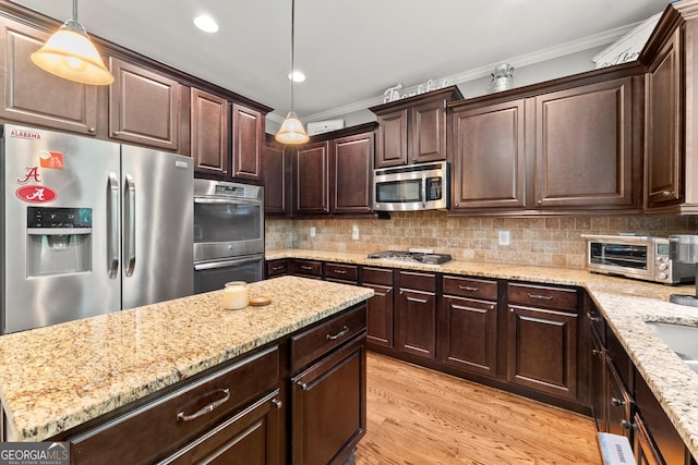 1050 Double Branches Ln, Dallas, GA 30132 - kitchen with appliances with stainless steel finishes, ornamental molding, dark brown cabinetry, light stone countertops, and pendant lighting