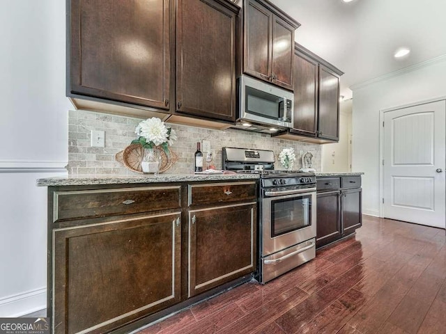 631 Naturewalk Blvd, Dallas, GA 30132 - kitchen featuring stainless steel appliances, dark brown cabinetry, light stone counters, crown molding, and tasteful backsplash