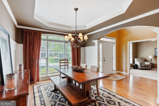 1320 Magnolia Park Cir, Cumming, GA 30040 - dining space featuring arched walkways, ornamental molding, a chandelier, wood finished floors, and a raised ceiling