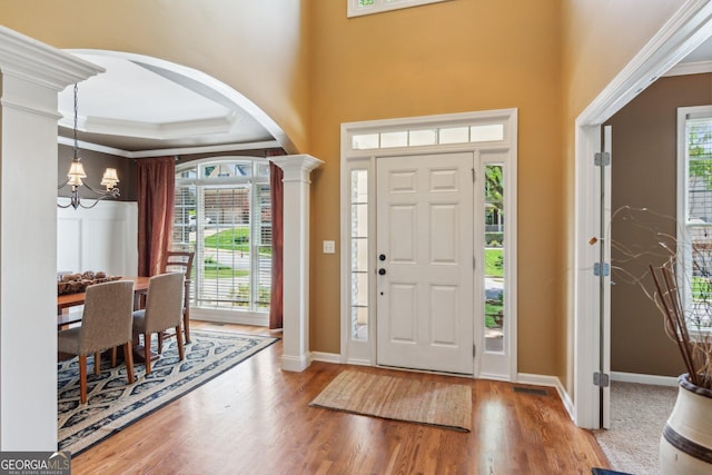 1320 Magnolia Park Cir, Cumming, GA 30040 - foyer featuring arched walkways, a chandelier, wood finished floors, ornamental molding, and a high ceiling