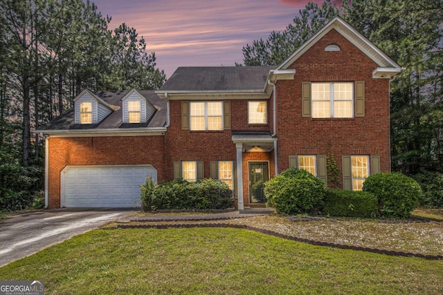 view of front of home with driveway, brick siding, an attached garage, and a lawn