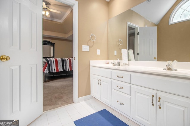 bathroom with ceiling fan, tile patterned floors, double vanity, lofted ceiling, and baseboards