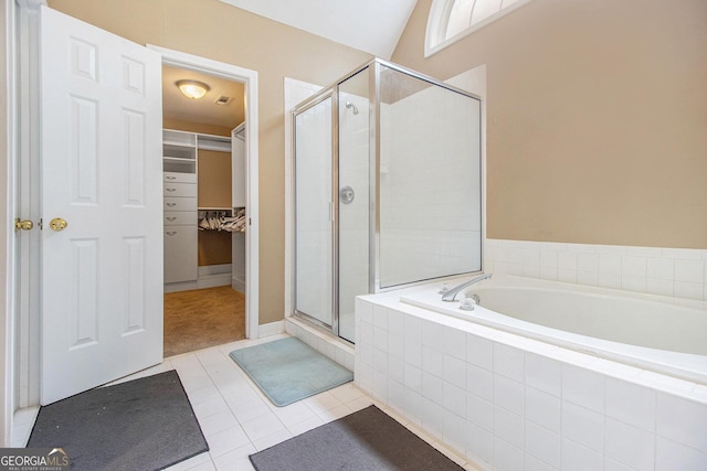 full bath featuring a shower stall, tile patterned floors, a spacious closet, and a garden tub