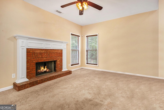 unfurnished living room featuring carpet flooring, ceiling fan, baseboards, and a fireplace