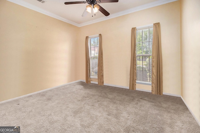 carpeted empty room featuring crown molding, a ceiling fan, healthy amount of natural light, and baseboards