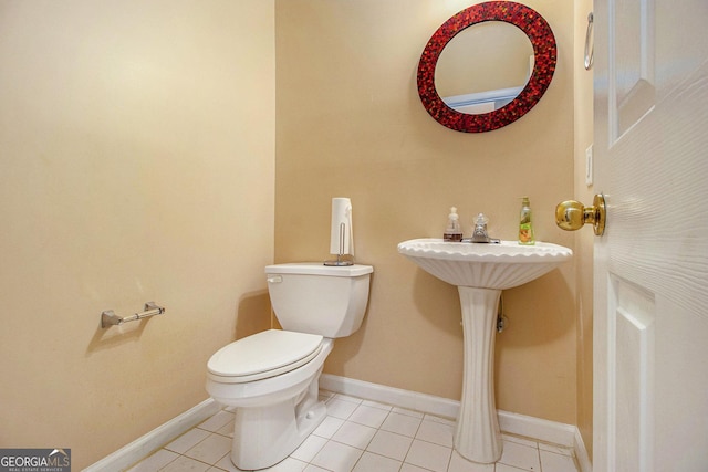 half bathroom featuring toilet, tile patterned floors, and baseboards