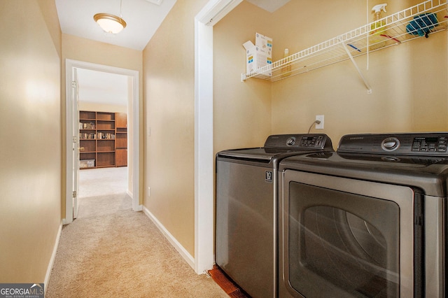 clothes washing area with washer and clothes dryer, carpet flooring, and baseboards